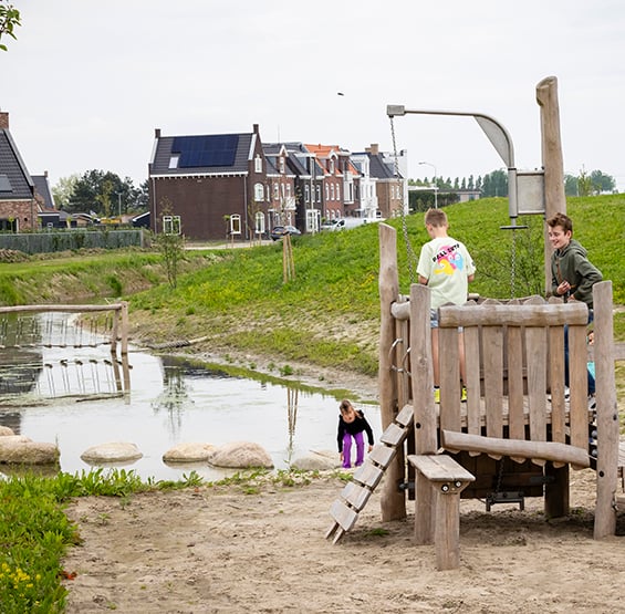 kinderen op speelrek in woonwijk bij water