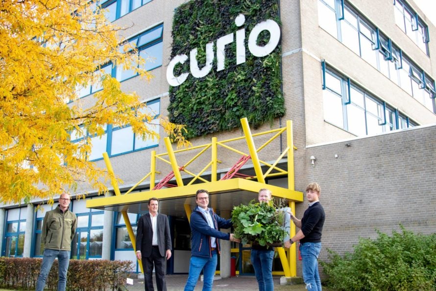 Bob Schalken (Curio), wethouder Paul de Beer (gemeente Breda) en Christaan Bakker (Sempergreen) met de studenten die het bedieningspaneel overhandigd krijgen.